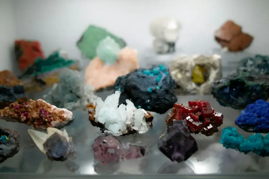 different colored raw gems sitting on a shelf